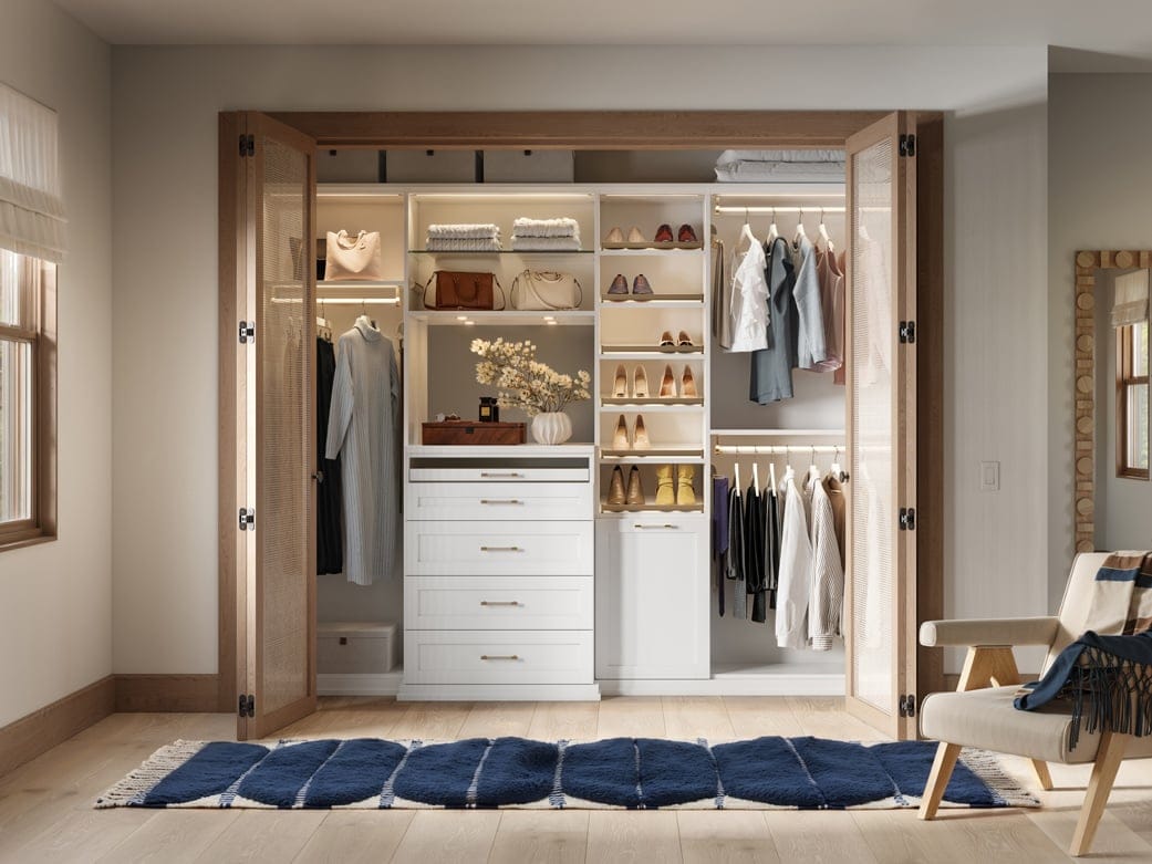 Reach in custom wardrobe closet with dresser and countertop, with laundry hamper by California Closets